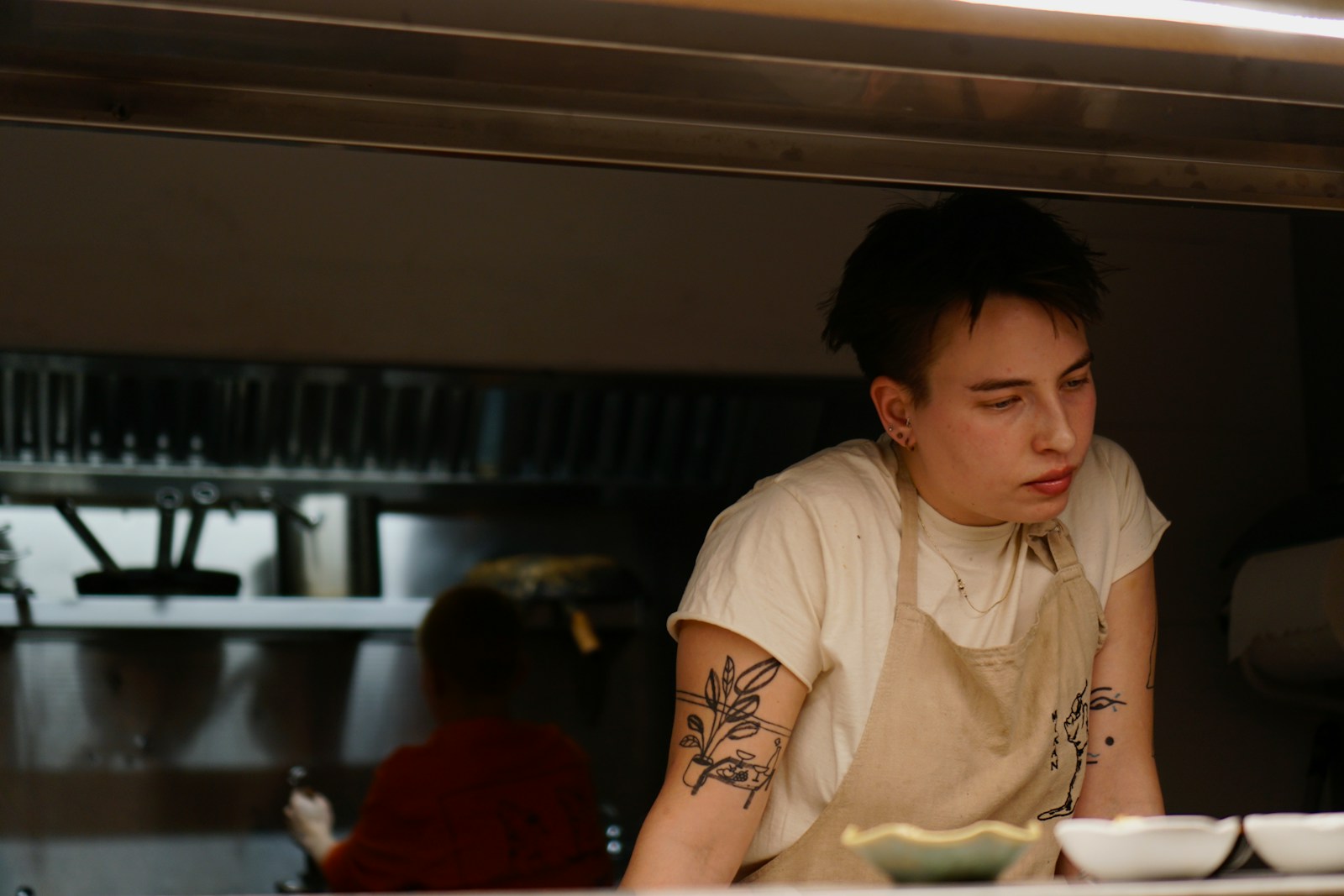 Photo by Alex Shih Mendez a man with a tattoo on his arm sitting at a table